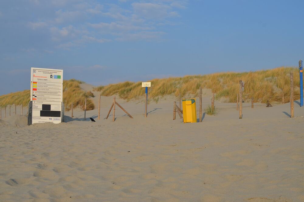 Breed zandstrand bij Arendsduin in 's-Gravenzande met duinen en een blauwe lucht